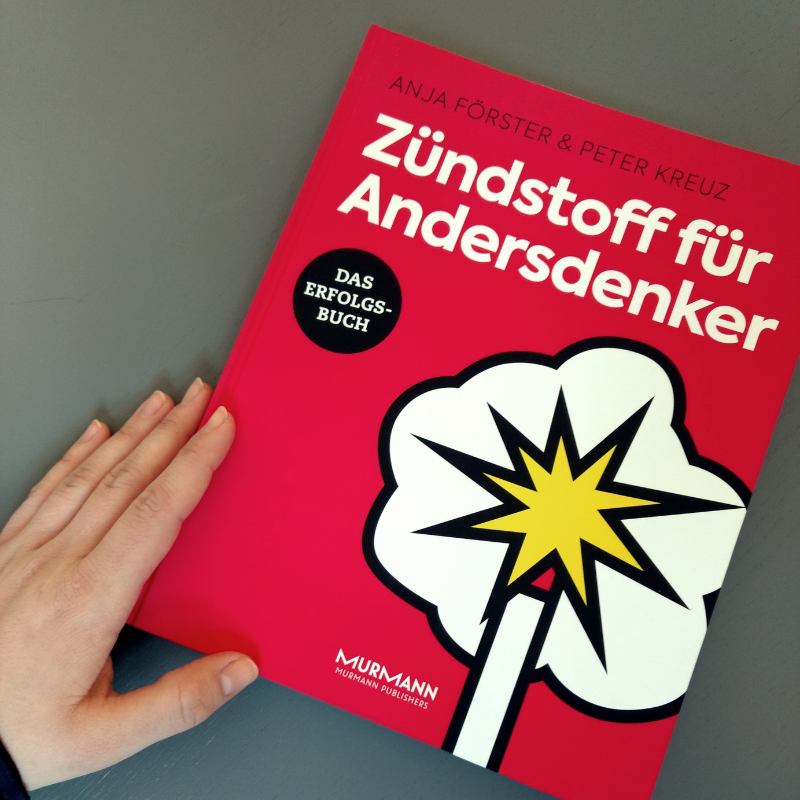 Hand links neben Buch Cover